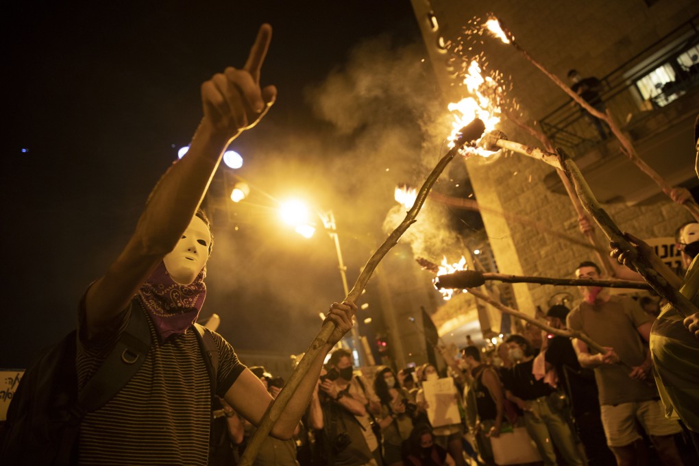 Protesters light torches during a protest against Israel's Prime Minister Benjamin Netanyahu outside his residence in Jerusalem. Photo: AP Photo