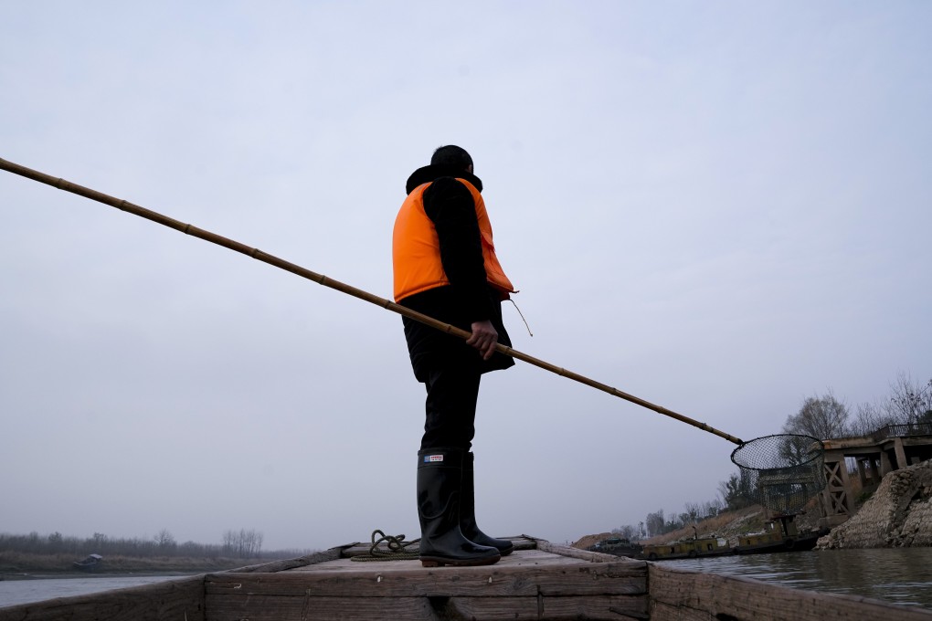 After giving up his licence, this fisherman clears rubbish from the Yangtze in Anhui province. Photo: Xinhua