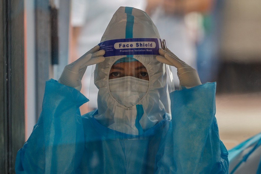 A health worker gestures while waiting for a patient at a swabbing booth in Quezon City, Metro Manila, as the number of coronavirus cases in the Philippines continues to soar. Photo: EPA-EFE