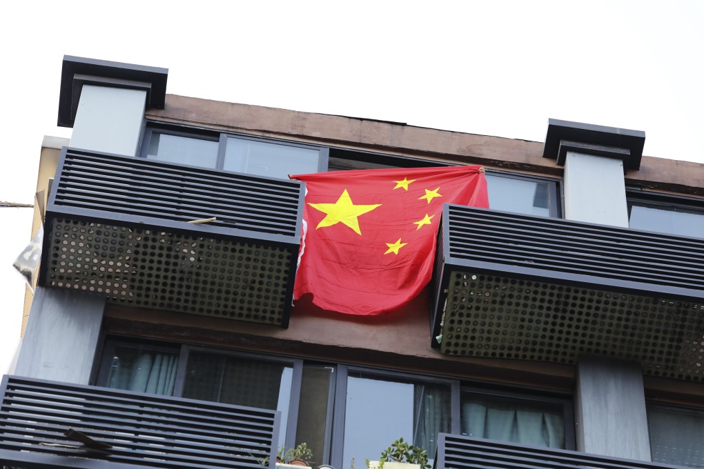 A local resident displays a Chinese national flag as he shouts “China carry on! Long Live China, Long Live the Communist Party!”, on top of a block of flats opposite the US consulate general in Chengdu, Sichuan province, on July 26. The Chinese government ordered the consulate to close, after the US told the Chinese Consulate General in Houston to do the same the previous week. Photo: Simon Song