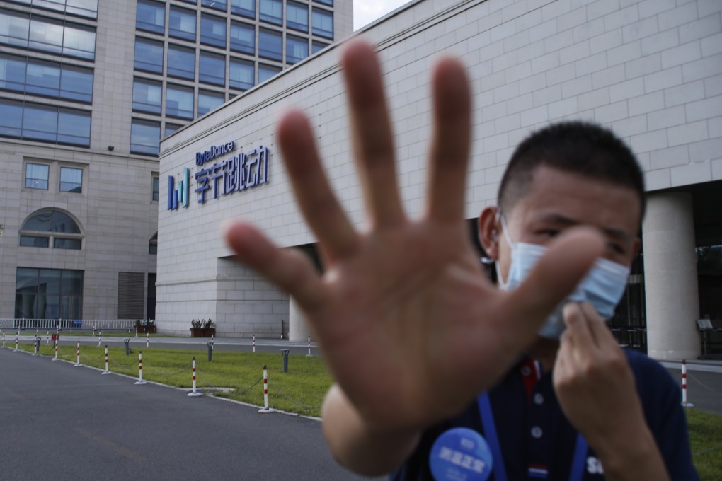 A security guard attempts to stop a photographer in front of the Bytedance headquarters building in Beijing, China, 03 August 2020. Photo: EPA-EFE