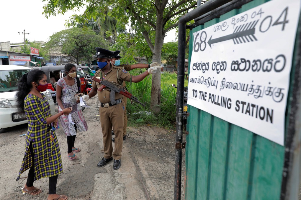 Police officers wearing face masks direct voters at a polling station during Sri Lanka’s parliamentary election in Colombo on Friday. Photo: Reuters
