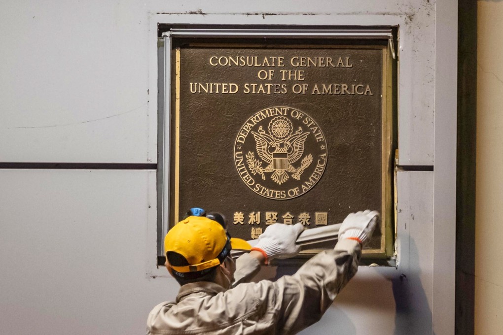 A man tries to remove a plate in front of the US consulate in Chengdu, Sichuan province, late last month after the office was order to close. Photo: EPA-EFE