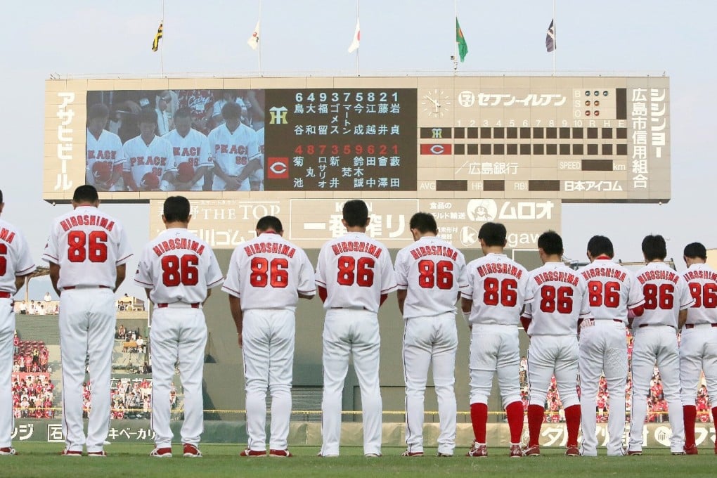 Hiroshima Toyo Carp players pray for atomic bomb victims before a game in Hiroshima on August 6, 2015. The city suffered the world’s first atomic bombing, but for locals, baseball helped boost morale on the road to recovery. Photo: AFP via Getty Images