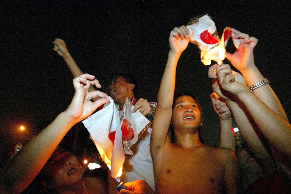 Chinese fans burn Japanese flags outside Workers’ Stadium in Beijing after China’s 3-1 loss to Japan in the 2004 AFC Asian Cup final. Photo: Reuters