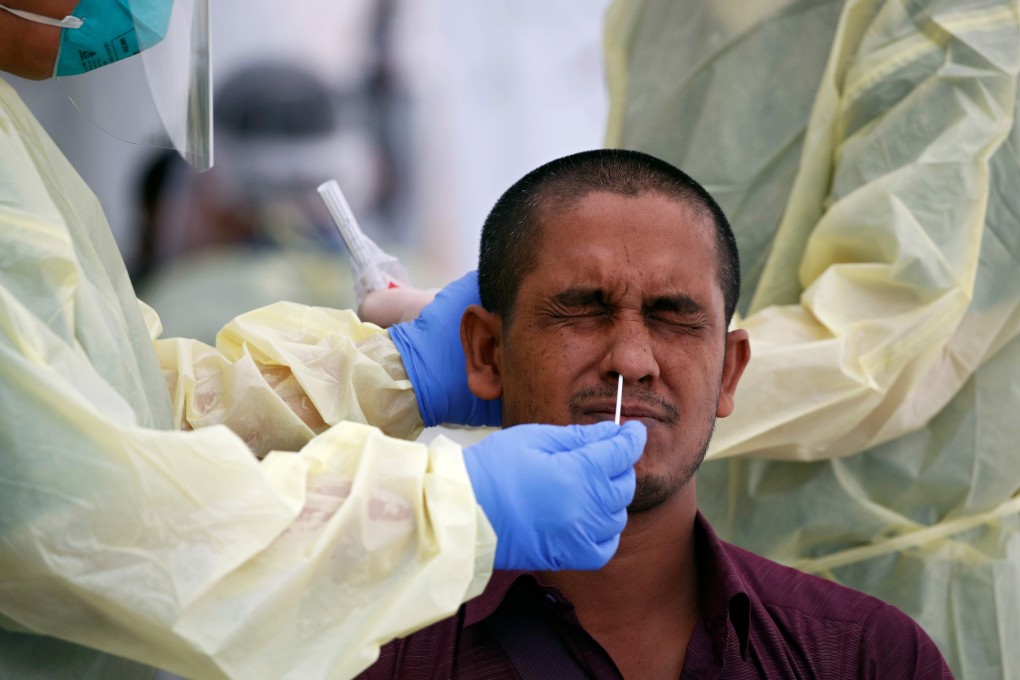 Medical workers perform a nose swab on a migrant worker at a dormitory in Singapore in May. Photo: Reuters