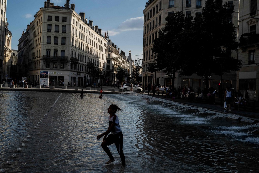 Children play in a fountain to cool off in Lyon, France. Photo: AFP