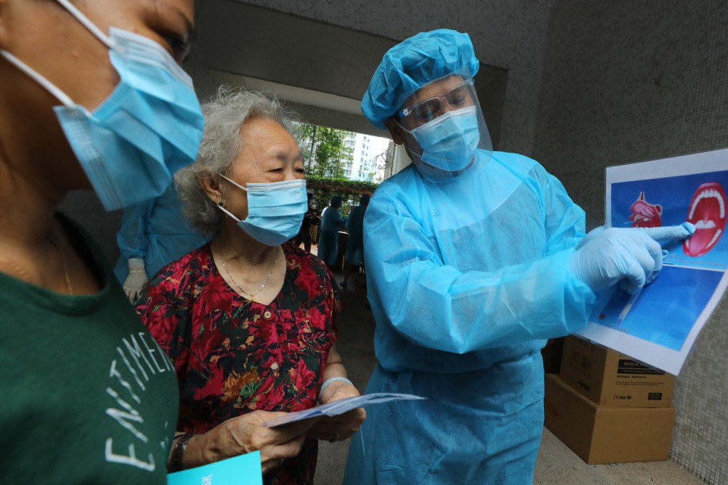 Hong Kong medical workers instruct city residents on how to use Covid-19 testing kits. The government on Friday announced a massive new programme that will allow for voluntary coronavirus testing beginning in two weeks. Photo: Dickson Lee