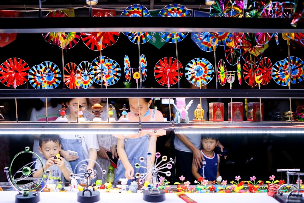 Tourists buy souvenirs at a shop in the city of Qingdao, in east China’s Shandong province, on July 25. President Xi Jinping recently said the country would pursue a new development plan, focusing on its domestic market rather than an export-led growth model. Photo: Xinhua