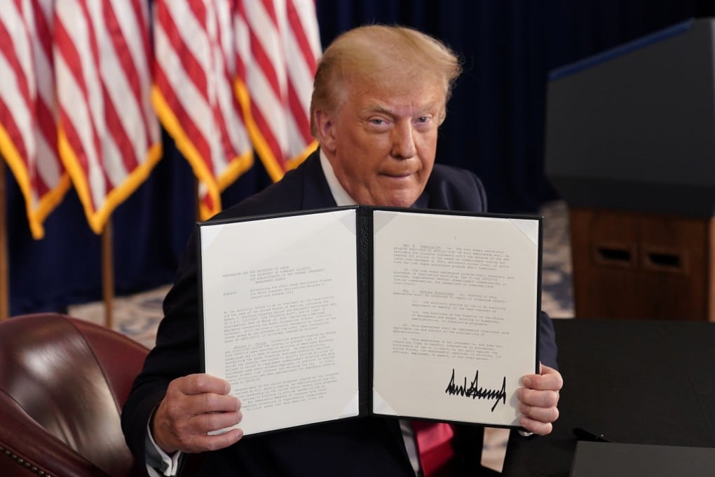 US President Donald Trump shows signed executive orders for economic relief during a news conference at his golf resort in Bedminster, New Jersey, on Saturday. Photo: Reuters