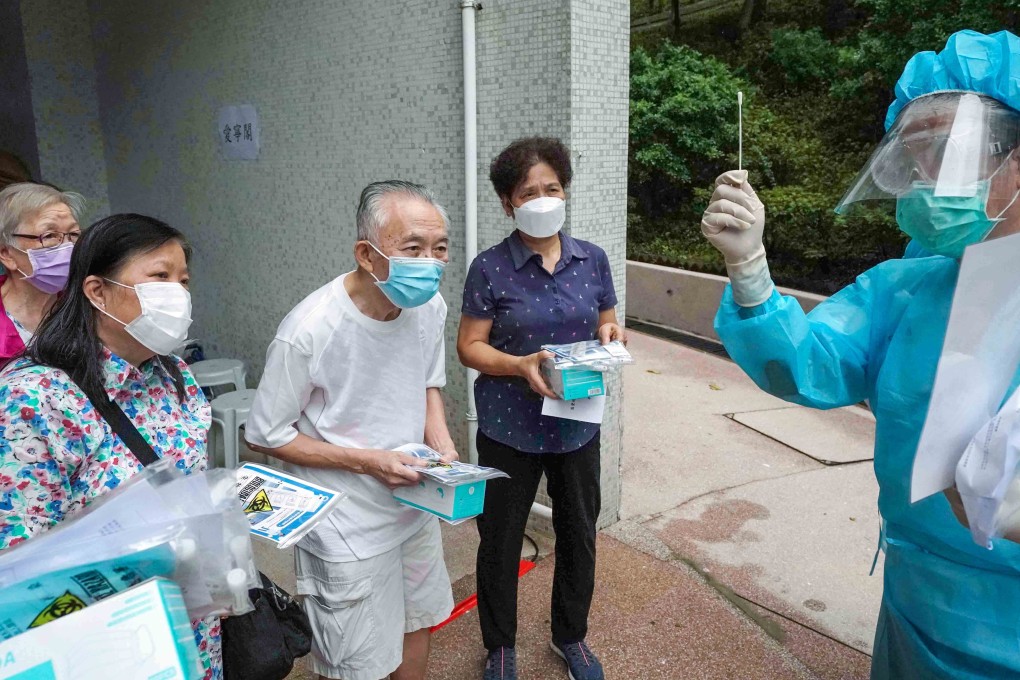 A health worker teaches residents of Tsz Oi Court in Wong Tai Sin how to use Covid-19 test kits. Photo: Felix Wong