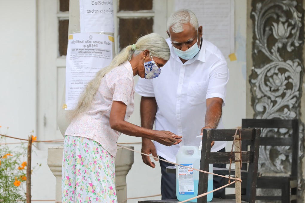 A voter uses hand sanitiser before entering a polling station during the parliamentary elections in Sri Lanka last week. Photo: EPA