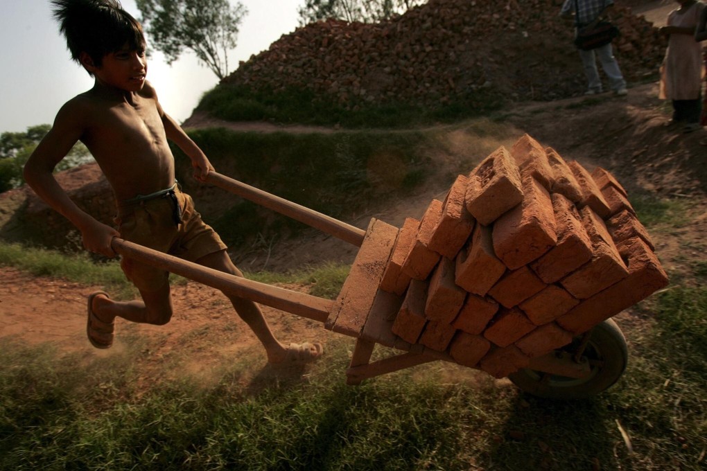 A child worker pushes a cart with bricks in Meerut city, India. File photo: EPA