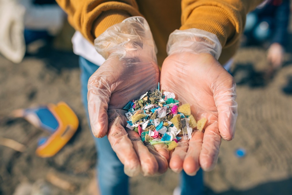 Detail of hands showing microplastics on the beach. Photo: Shutterstock