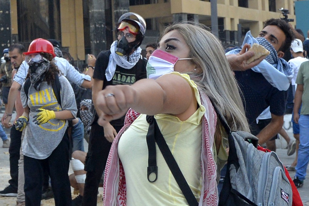 Lebanese anti-government protesters throw stones at security forces in Beirut on Monday. Photo: EPA-EFE