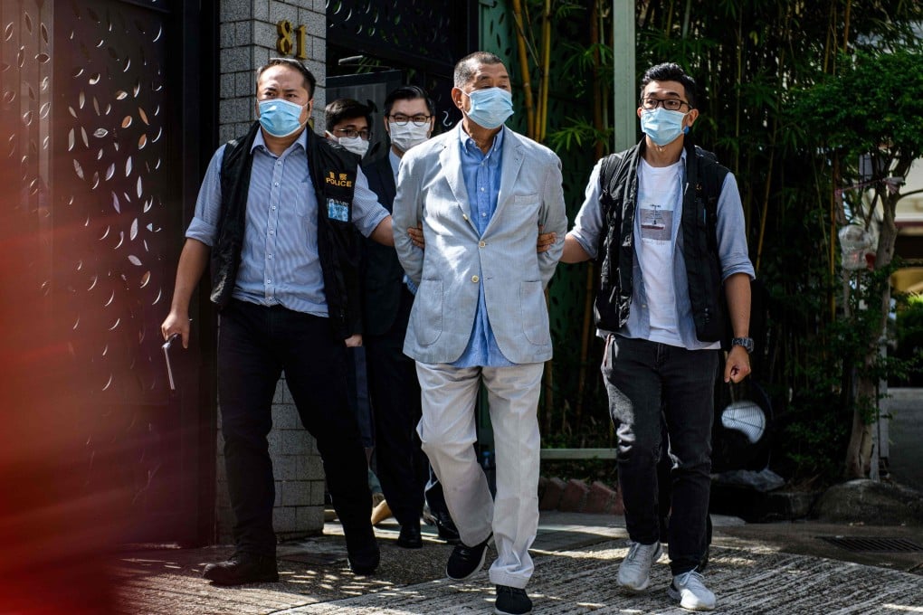 Police lead Jimmy Lai (centre) away from his home after he was arrested in Hong Kong on Monday. Photo: AFP