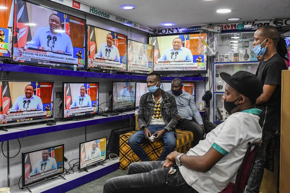 People in a Nairobi electronics shop watch President Uhuru Kenyatta giving an address on the pandemic on Monday. Kenyatta has banned the sale of alcohol in eateries and restaurants, extended a curfew and delivered a stern dressing down to Kenyans for “reckless” behaviour. Photo: AFP