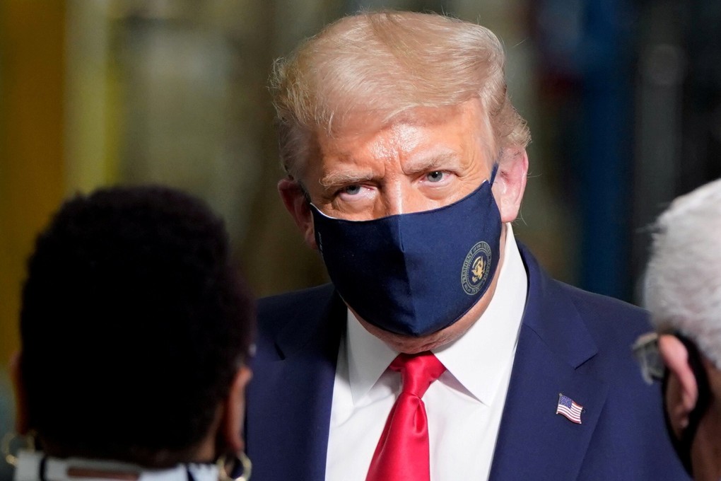 US President Donald Trump wears a protective face mask due to the coronavirus disease pandemic as he talks with workers while touring a Whirlpool Corporation washing machine factory in Clyde, Ohio, on August 6, 2020. Photo: Reuters