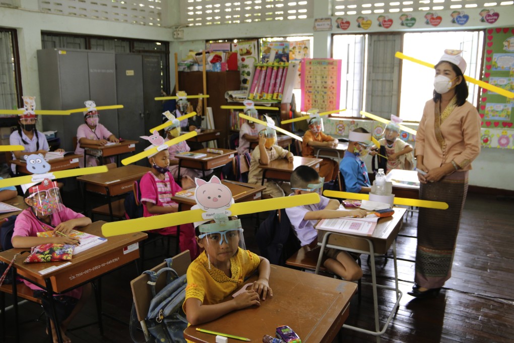 A teacher and students wearing hats designed for space keeper, practice social distancing to help curb the spread of the coronavirus. Photo: AP