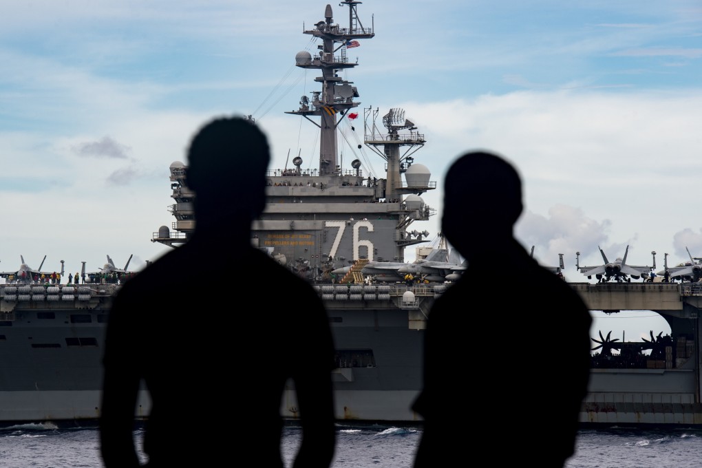 US Navy personnel on board the USS Nimitz aircraft carrier with the USS Ronald Reagan in the background. Photo: EPA-EFE