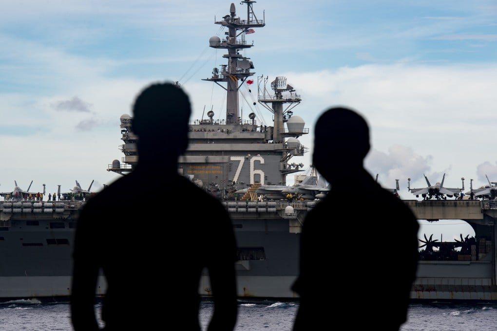 US Navy personnel on board the USS Nimitz aircraft carrier with the USS Ronald Reagan in the background. Photo: EPA-EFE