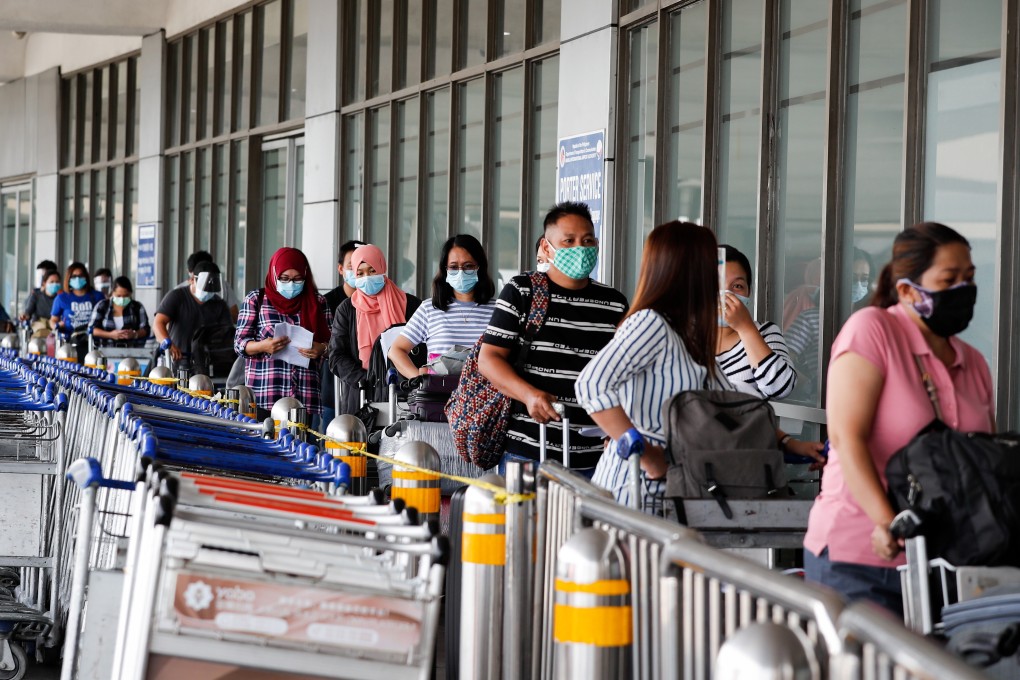Passengers queue up for temperature checks before entering Manila’s Ninoy Aquino International Airport on August 3. Photo: EPA