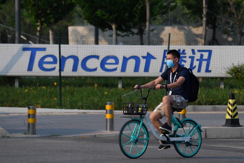 Tencent’s second-quarter net income beat expectations. Here, a man bikes past a sign for Tencent in Beijing. Photo: Agence France-Presse