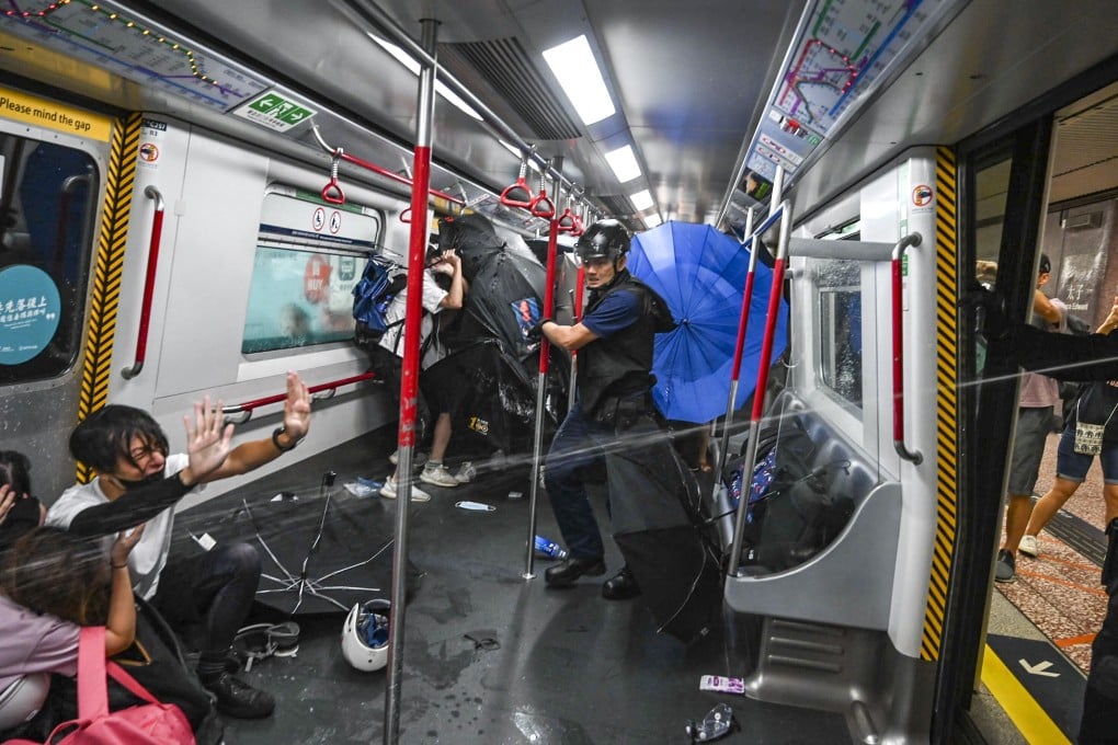 Police officers use pepper spray in a train carriage at a platform of the station. Photo: Handout
