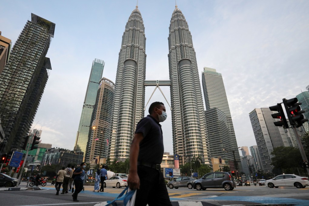 A man walks in front of the Petronas Twin Towers in Kuala Lumpur. Malaysia’s economy contracted in the second quarter as a result of the Covid-19 restrictions. Photo: Reuters