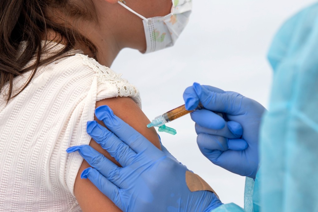A health worker administers a vaccine to a child. With no vaccine or natural herd immunity, Covid-19 is likely to become endemic. Photo: AFP