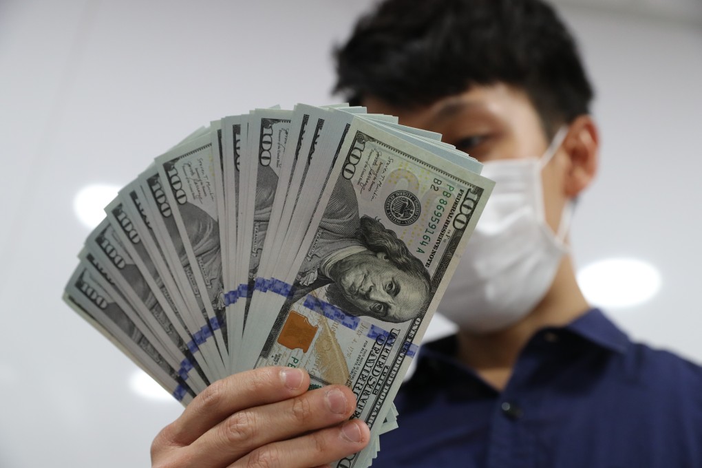A Hongkonger holds up his US dollars in Sham Shui Po on May 29. People exchanged the Hong Kong dollar for foreign currencies in fear of the local currency dropping in light of the approved national security law. Photo: Edmond So