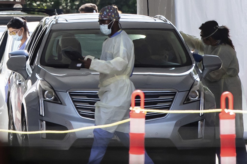 A health care worker collects a sample from a motorist at a Covid-19 testing facility in Burnaby, British Columbia, on Thursday. Photo: Canadian Press via AP