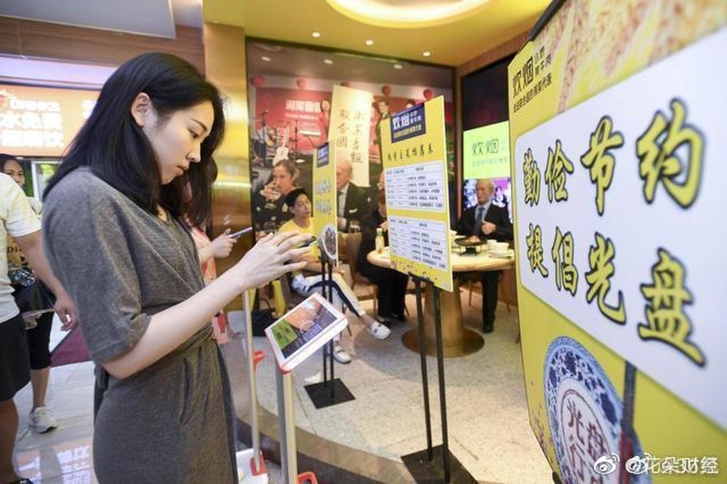 A woman checks her weight at the entrance to the Chuiyan Fried Beef restaurant in Changsha. Photo: Weibo