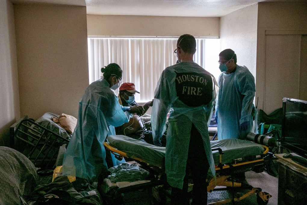 First responders move a patient with Covid-19 symptoms onto a stretcher before transporting him to a hospital in Houston, Texas. Photo: AFP