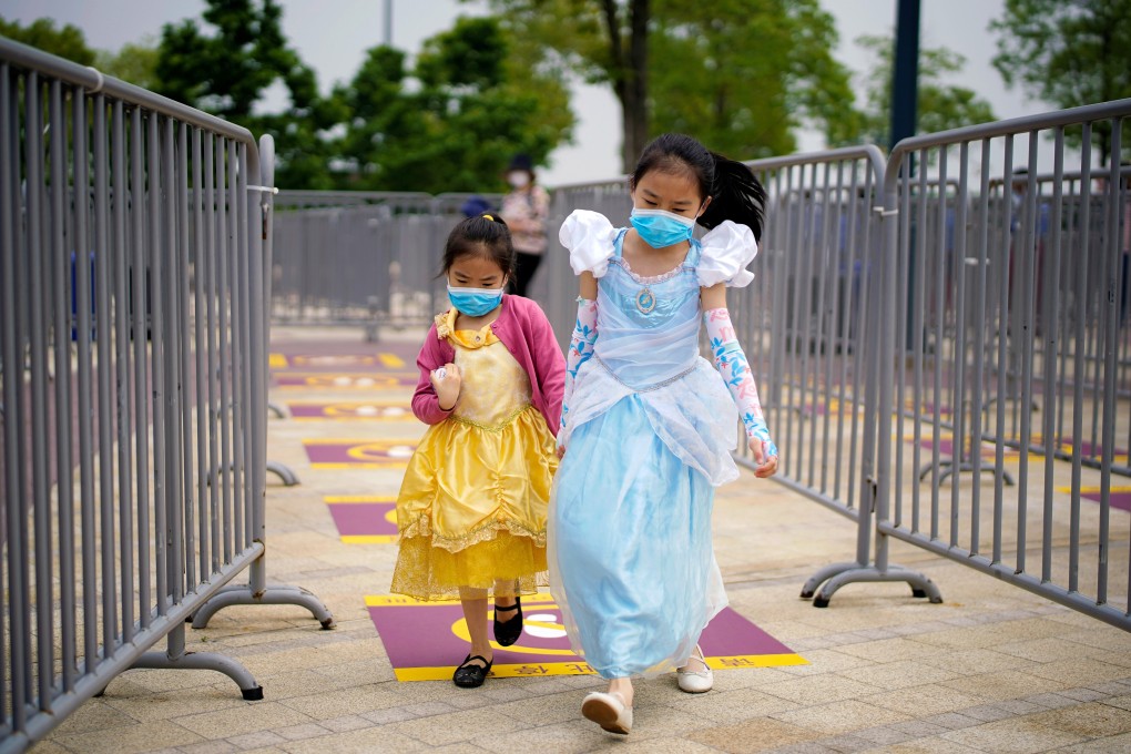 Children wearing face masks walk past social distancing markers to enter Shanghai Disneyland on May 11. China is the world’s most populous country now, but research suggests its population could shrink by half by 2100. Photo: Reuters