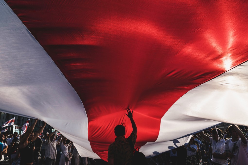 Protesters unfurl a banner in the colours of the former Belarus national flag in Minsk, Belarus, on Sunday. Photo: Bloomberg
