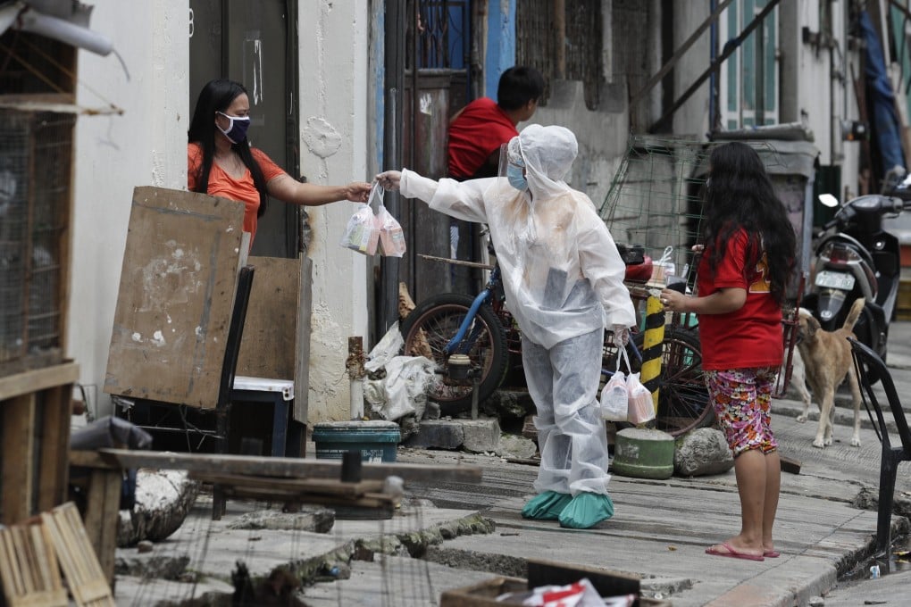 A health worker distributes medicines and vitamins to a resident of an area placed under stricter lockdown measures to curb the spread of Covid-19 in the Philippines. Photo: AP