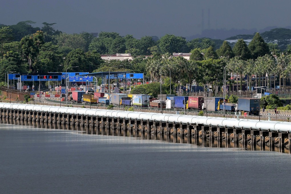 Trucks pass across the Johor Causeway on the first day of the opening of the border between Malaysia and Singapore on Monday. Photo: DPA
