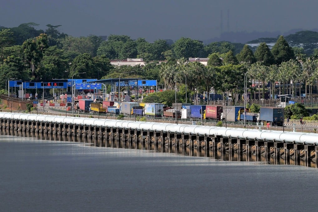 Trucks pass across the Johor Causeway on the first day of the opening of the border between Malaysia and Singapore on Monday. Photo: DPA