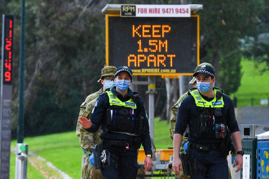 Police officers and soldiers patrol a popular running track in Melbourne. Photo: AFP
