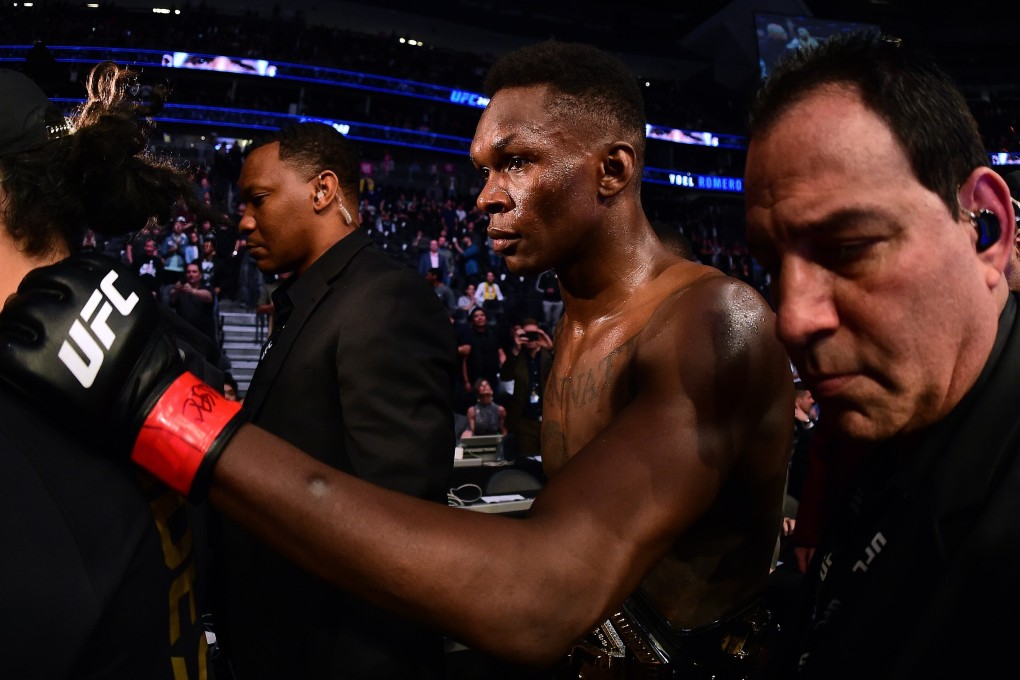 Israel Adesanya is escorted out of the ring after a decision win over Yoel Romero during a middleweight title bout at UFC 248. Photo: AFP