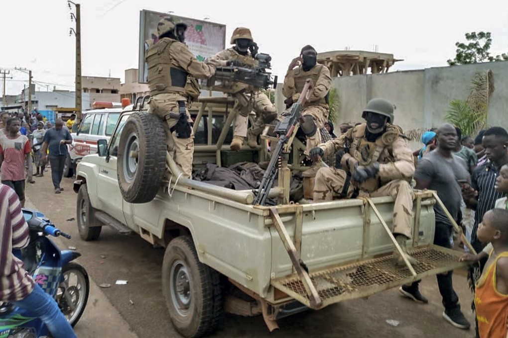 Malian troops and citizens gather outside the private residence of President Ibrahim Boubacar Keita in Bamako on Tuesday. Photo: AP