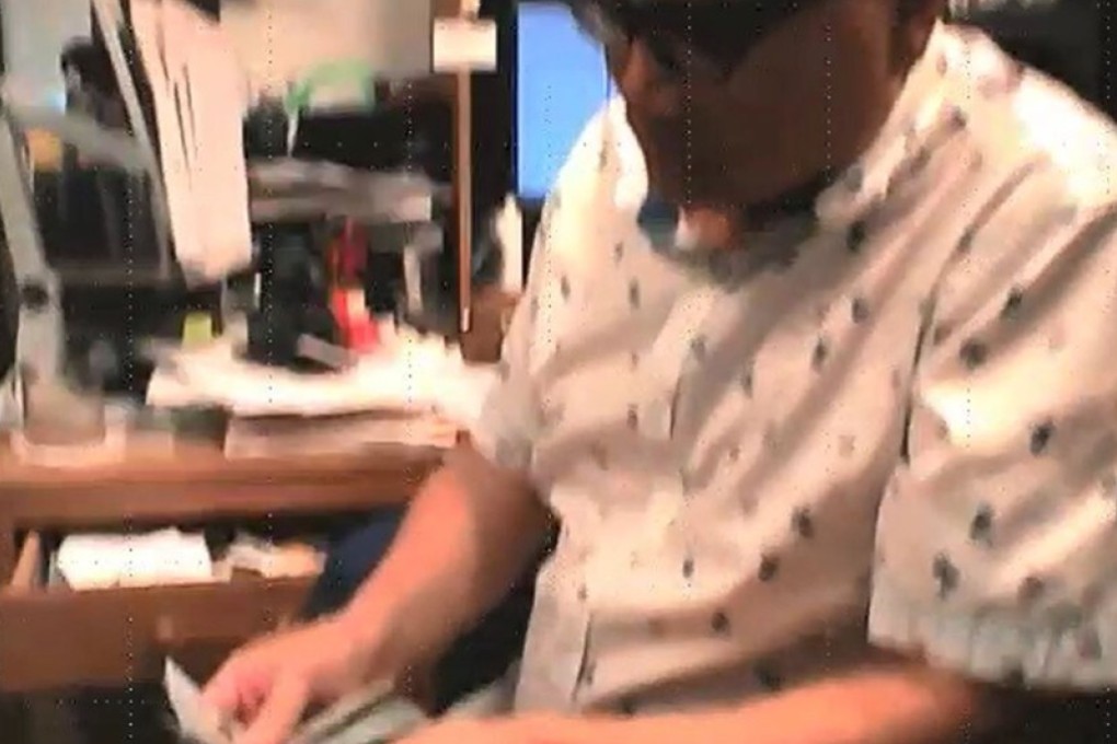 A still taken from an FBI video is said to show former CIA officer Alexander Ma accepting US$2,000 from an undercover agent posing as a Chinese operative. Photo: US Justice Department handout via TNS