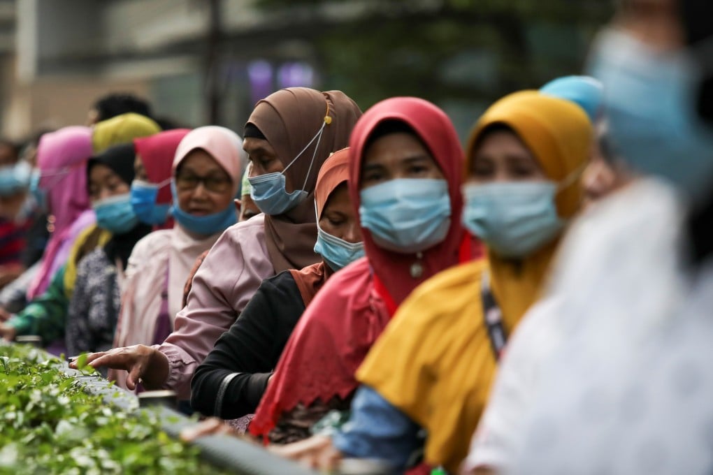 Women queue at a bus station in Kuala Lumpur, Malaysia. Photo: Reuters