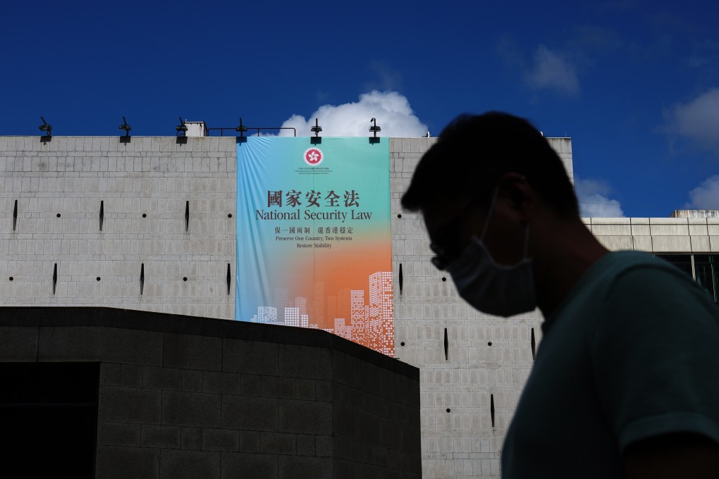 A man walks past a banner promoting the national security law in Central. Photo: Sam Tsang