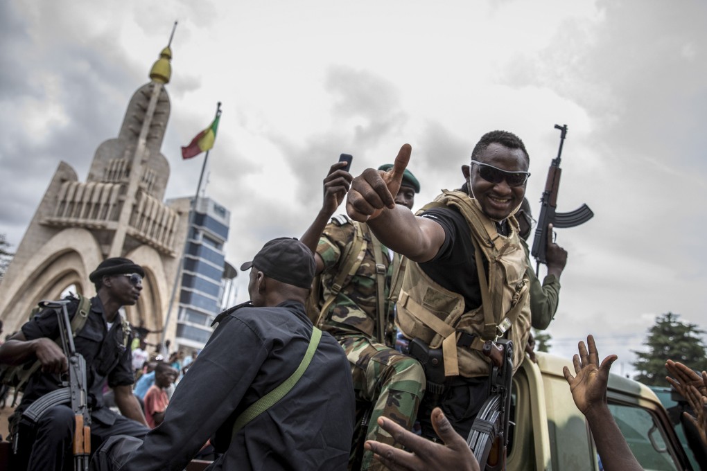 A Malian soldier gives the thumbs up as civilians cheer for troops and police driving through the streets of Bamako on Wednesday. Photo: EPA-EFE