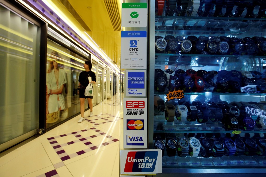 Digital payment brands are displayed outside a watch shop in a mall in Hong Kong. Photo: Reuters
