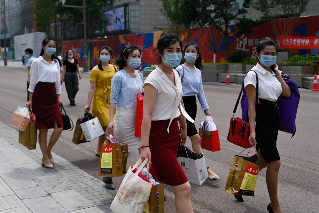 Women have become a driving force of consumption in China. Here, women wearing walk along a business street after shopping in Beijing. Photo: Agence France-Presse)