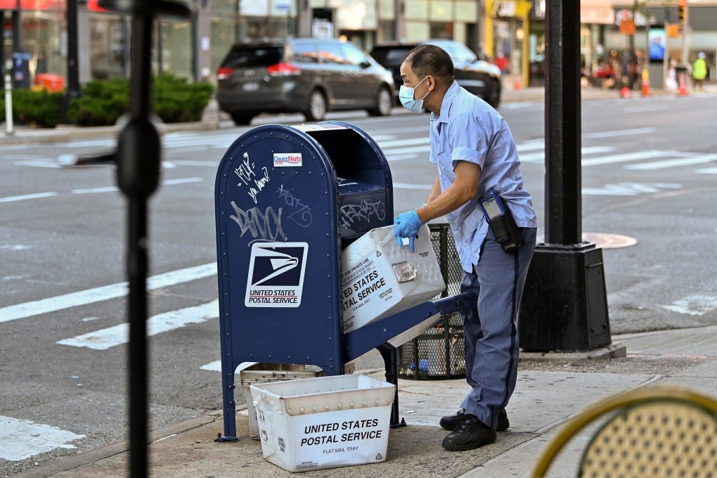 A United States Postal Service (USPS) worker wearing a protective mask and gloves makes his rounds in the Chelsea neighbourhood of Manhattan. Photo: AFP