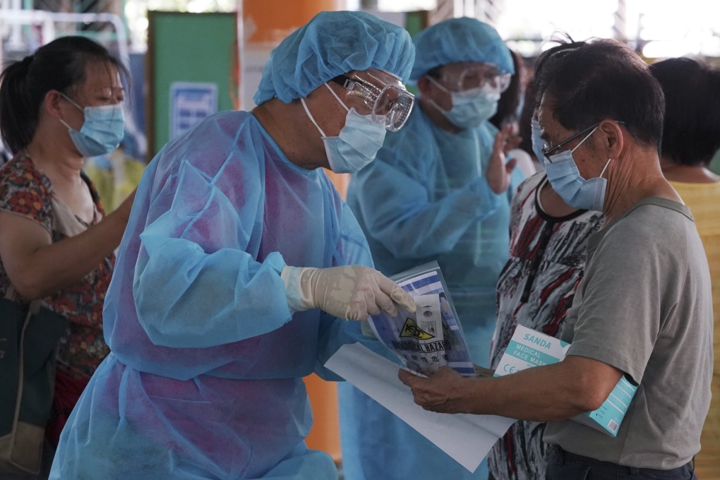 Residents collect test kits from health care workers in Tuen Mun in a separate one-off scheme earlier amid the emergence of a cluster there. Photo: Felix Wong